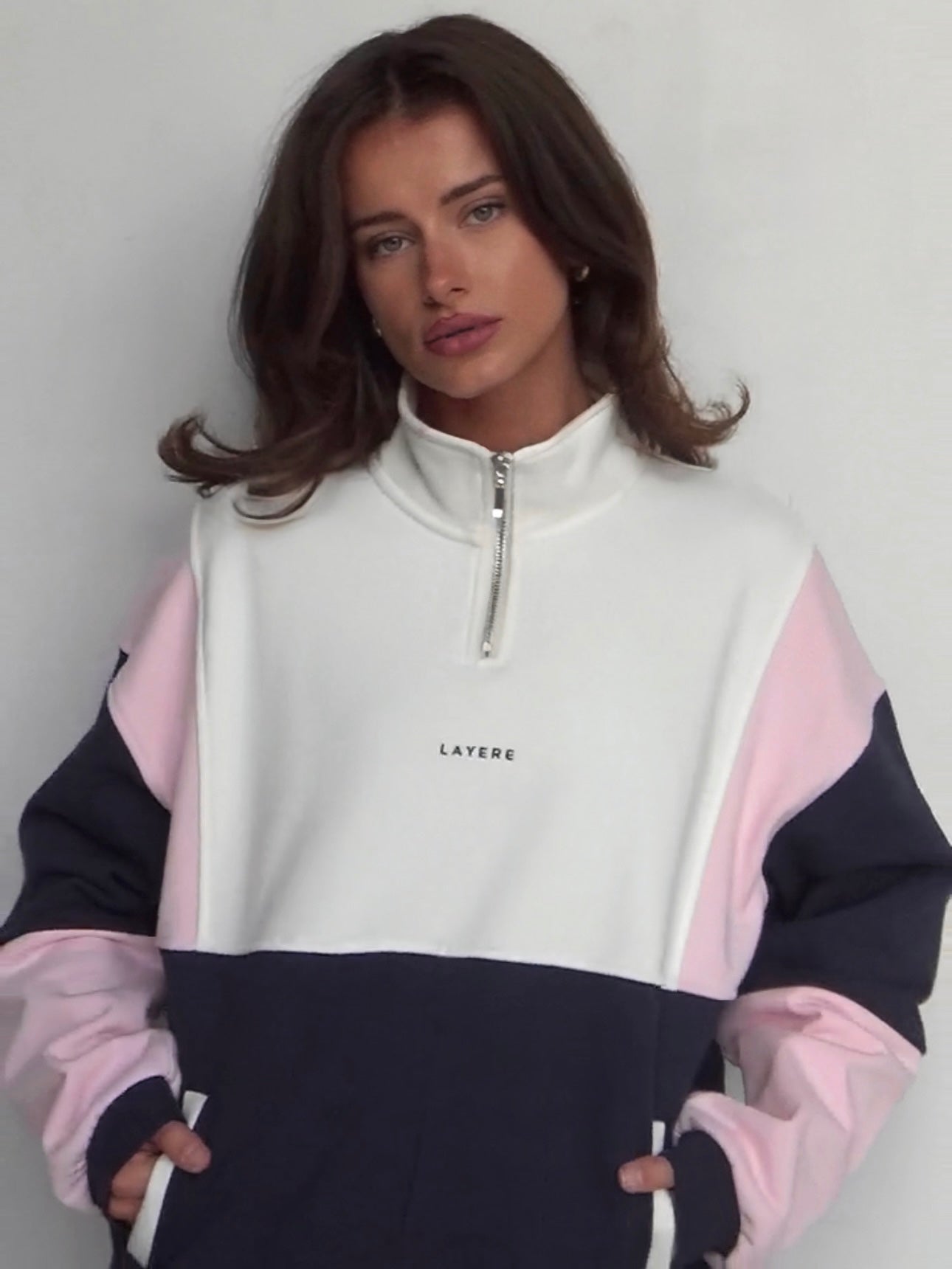 Person wearing an organic cotton color-blocked 90s pullover with 'LAYERE' branding against a plain background