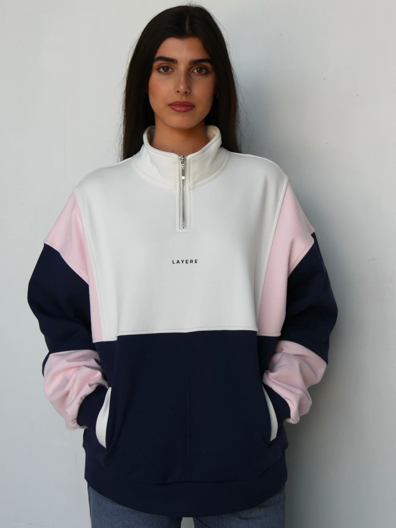 Person wearing an organic cotton color-blocked 90s pullover with 'LAYERE' branding against a plain background