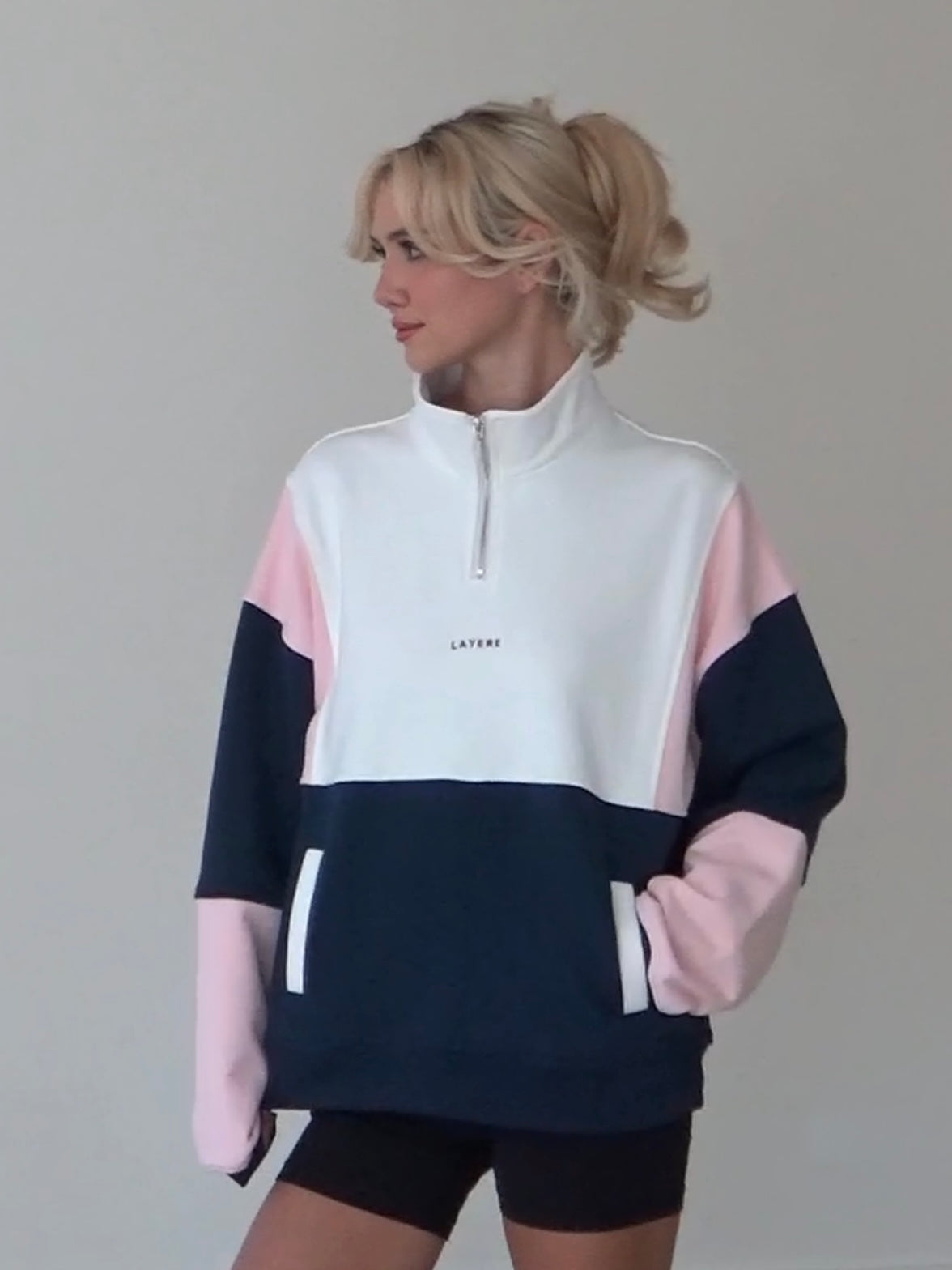 Person wearing an organic cotton color-blocked 90s pullover with 'LAYERE' branding against a plain background